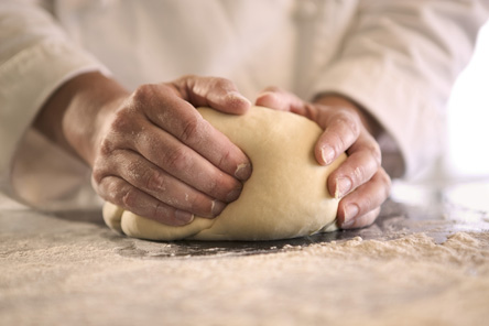 Close-up of a chef's hands kneading dough