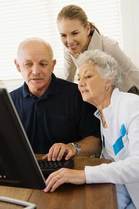 Woman helping couple use computer